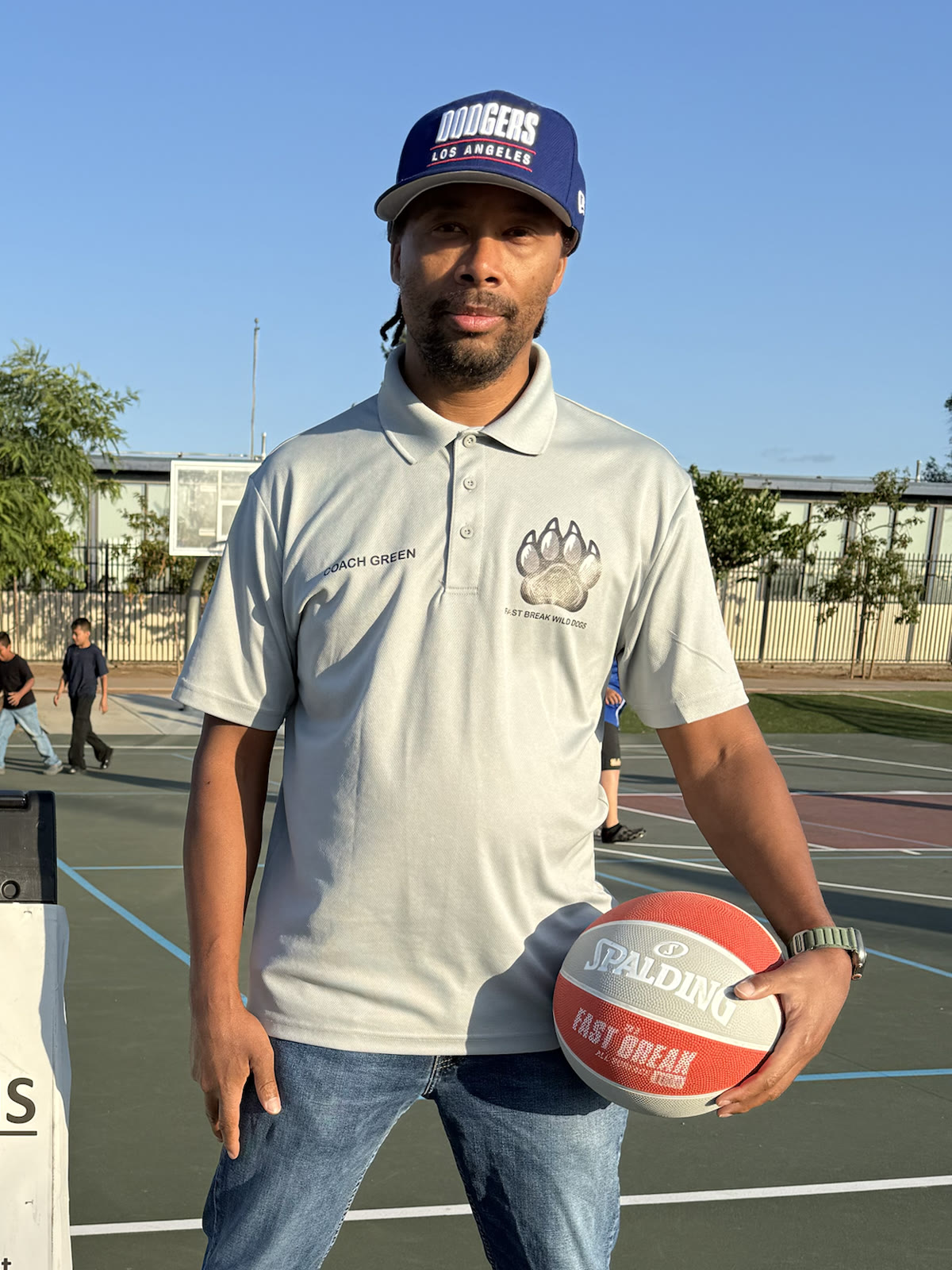 Coach LaShaun Green holding a basketball on an outdoor court