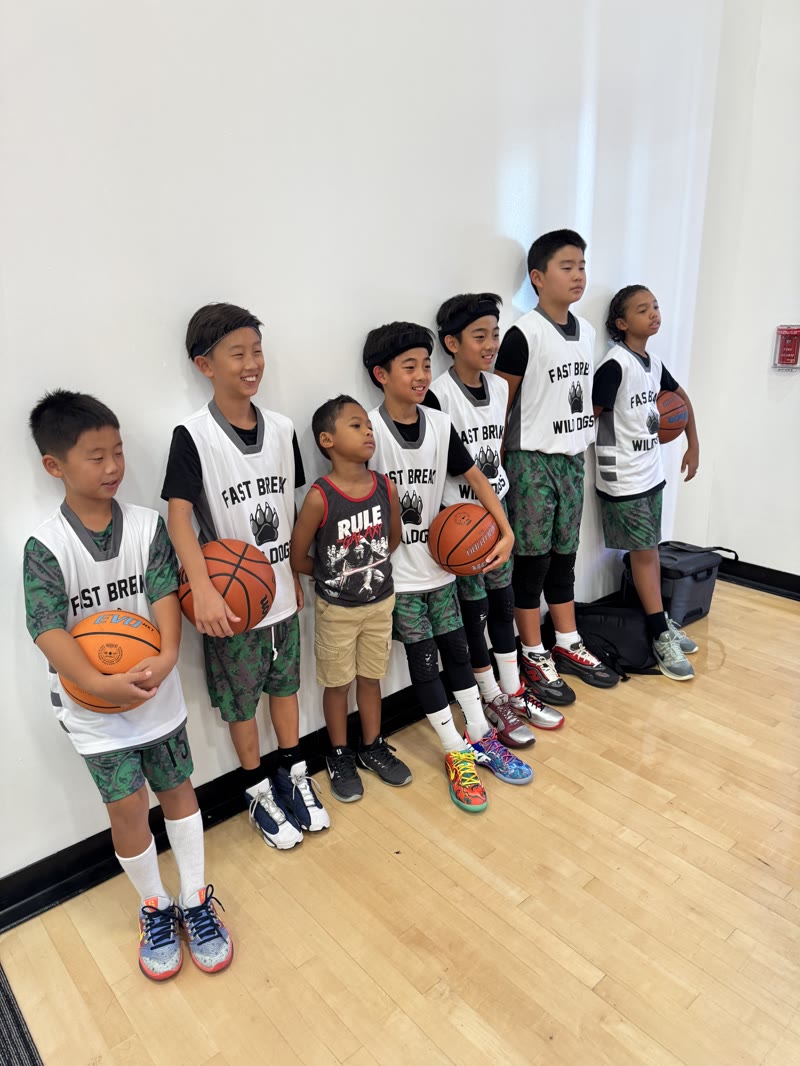 Fast Break Wild Dogs youth players standing together with basketballs